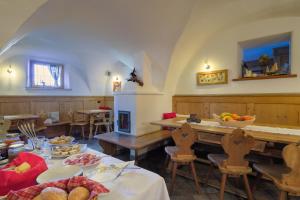 uma sala de jantar com uma mesa com comida em Maso Vaia em Cavalese