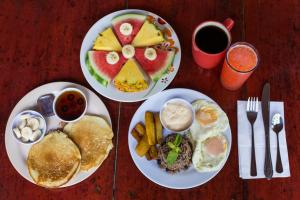 two plates of breakfast food on a wooden table at Jungle Beach Hotel Manuel Antonio in Manuel Antonio