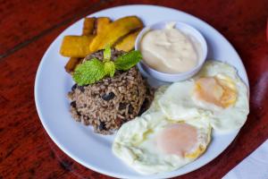 a plate of food with eggs and rice and french fries at Jungle Beach Hotel Manuel Antonio in Manuel Antonio