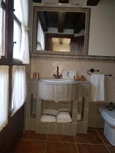 a bathroom with a sink, toilet and a window at Hotel Velad in Vélez Blanco