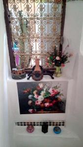 une photo sur un mur avec une fenêtre et des fleurs dans l'établissement Dar Al Taaj, à Rabat