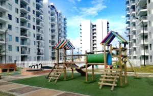 un parque infantil frente a algunos edificios altos en Depto Condominio Aqualina, en Girardot