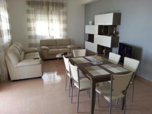 a living room with a table and chairs and a couch at Villa Fiorella in Sciacca