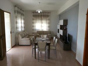 a living room with a table and chairs and a couch at Villa Fiorella in Sciacca