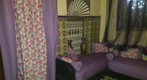 a living room with a purple couch and curtains at Dar Al Taaj in Rabat