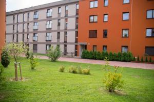 un immeuble d'appartements avec une pelouse devant lui dans l'établissement Apartament, à Cracovie