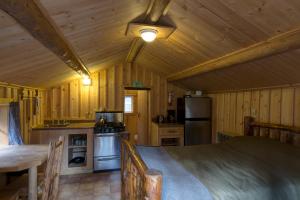 una cocina con paredes de madera y una mesa en una cabaña en Silver Gate Lodging en Cooke City