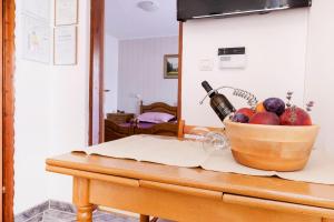 eine Schale Obst und eine Flasche Wein auf dem Tisch in der Unterkunft Apartment Pula 6 in Pula