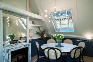 a dining room table with chairs and a large window at Maison Armance - Esprit de France in Paris