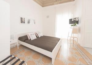 ein weißes Schlafzimmer mit einem großen Bett in einem Zimmer in der Unterkunft Dimora CentroWell in Palermo