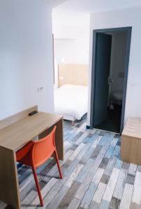 リモージュにあるWelcomotel Limogesのベッド付きの客室で、デスクと椅子が備わります。