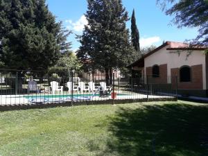 a fence with chairs and a pool in a yard at La Casa de Ana in Bialet Massé