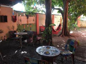 a patio with tables and chairs under a tree at Gira Arte Hostel in Recife