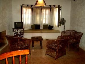 a living room with a couch and chairs and a television at Cabañas La Paloma in La Paloma +28 photos