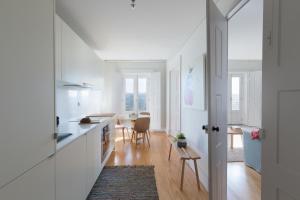 a kitchen with white cabinets and a dining room at B28 Apartments Porto in Porto