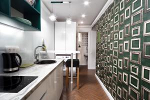 リヴィウにあるGreen apartmentの緑と白の壁に絵が飾られたキッチン