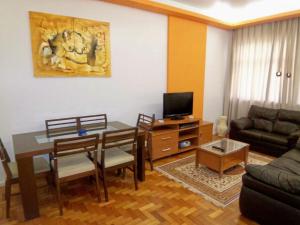 - un salon avec un canapé et une table avec des chaises dans l'établissement Aires 92, à Rio de Janeiro