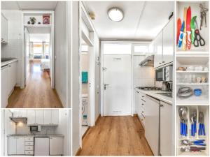 a white kitchen with white cabinets and wooden floors at Apartamentos Olympia in Playa de las Americas