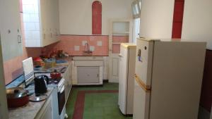 a kitchen with a white refrigerator and a green floor at Hostal, home sweet home in Salto