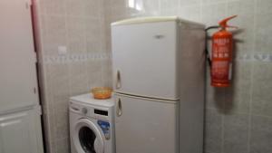 a white refrigerator and a washing machine in a kitchen at HAUS NUNES by Stay in Alentejo in Vila Nova de Milfontes