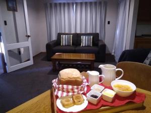 een woonkamer met een tafel en een dienblad met eten bij Magnolia Cottage B&B in Pleasant Point