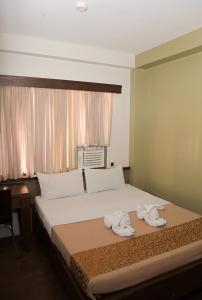 - une chambre avec un lit et des serviettes dans l'établissement Optimum Pension House, à Dumaguete