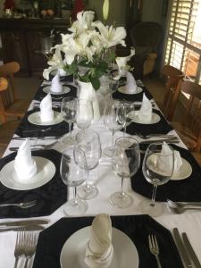 einen Tisch mit Weingläsern und eine Vase mit weißen Blumen in der Unterkunft Kippilaw House in Picton