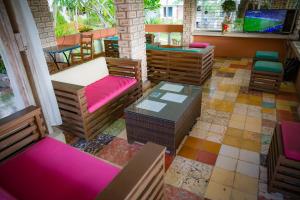 una habitación con sillas y mesas coloridas en un restaurante en Hotel Restaurant Cyvadier Plage en Jacmel