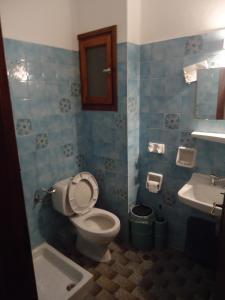 a bathroom with a toilet and a sink at Plaza Hotel in Skala