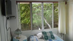 a bedroom with two windows and a bed and a television at Palma del Mar 2 in Puerto Baquerizo Moreno