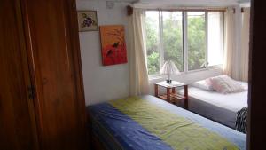 1 dormitorio con 2 camas y ventana en Palma del Mar 2 en Puerto Baquerizo Moreno