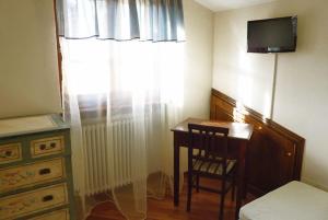 um quarto com uma secretária e uma janela com uma televisão em B&B Maesta' Di Cudino em Arezzo