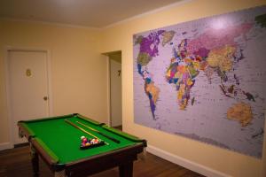 a room with a pool table and a map on the wall at Port Macquarie Backpackers in Port Macquarie