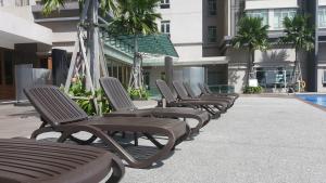 サイバージャヤにある10am-6pm, SAME DAY CHECK IN AND CHECK OUT, Work From Home, 1 Bedroom Apartment, Shaftsbury-Cyberjaya, G-Floor by Flexihome-MYの建物前の一列のラウンジチェア