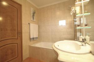 a bathroom with a sink and a bath tub at Condominio do Mar in Lagos
