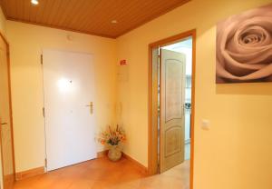 a hallway with a door and a vase of flowers at Condominio do Mar in Lagos