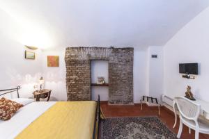 a bedroom with a bed and a brick wall at Rifugio degli Artisti in Rome