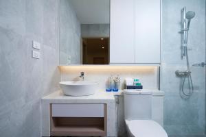 a bathroom with a sink and a toilet and a shower at Shama Lakeview Asoke Bangkok in Bangkok