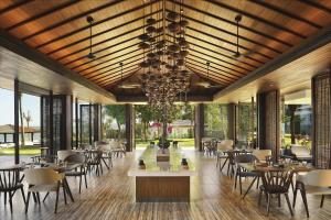 a dining room with tables and chairs and a chandelier at Anantara Quy Nhon Villas in Quy Nhon