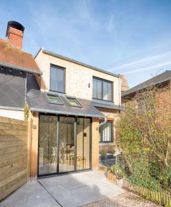 una extensión a una casa de ladrillo con puertas de cristal en The Tiny House, en Honfleur