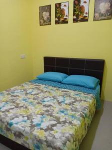 a bedroom with a bed with blue pillows on it at Mutiara Inn GuestRoom in Kampung Gurun