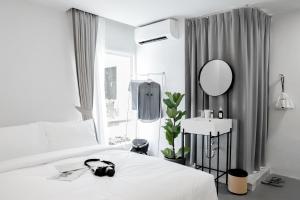 a bedroom with a bed and a mirror and a sink at Chocolate box mint - SHA Plus in Bangkok +54 photos