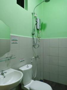 y baño con aseo y lavamanos. en Mutiara Inn GuestRoom, en Kampung Gurun