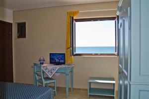 a bedroom with a desk with a computer and a window at Lido Impero in Palagiano