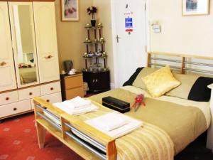 1 dormitorio con 1 cama con mesa y espejo en Park View Guest House, en York