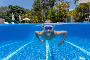 a man in a swimming pool wearing sunglasses at Ingenia Holidays Noosa North in Tewantin