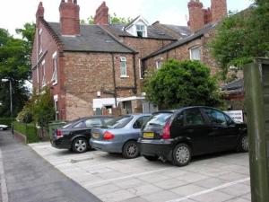 three cars parked in a parking lot in front of a building at Park View Guest House in York