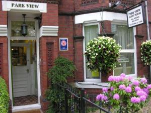 a brick house with pink flowers in front of it at Park View Guest House in York