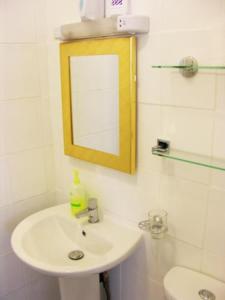 Baño blanco con lavabo y espejo en Park View Guest House, en York