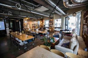 a restaurant with tables and couches in a room at Olle Stay in Seogwipo
